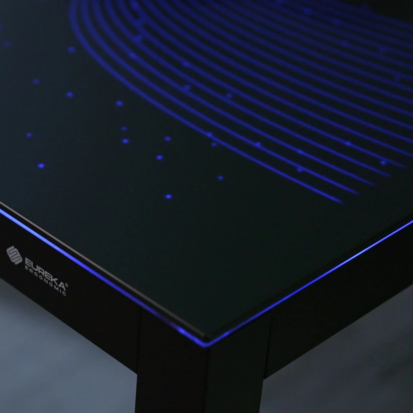 Close-up view of the premium tempered glass surface and integrated RGB light strips on the Eureka Ergonomic desk.