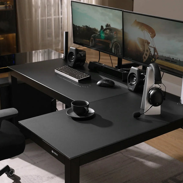 Modern gaming command center featuring the Eureka Ergonomic L-shaped glass desk with a dual monitor setup.