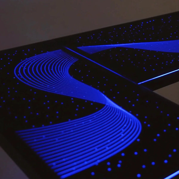 Close-up view of the premium tempered glass surface and integrated RGB light strips on the Eureka Ergonomic desk.